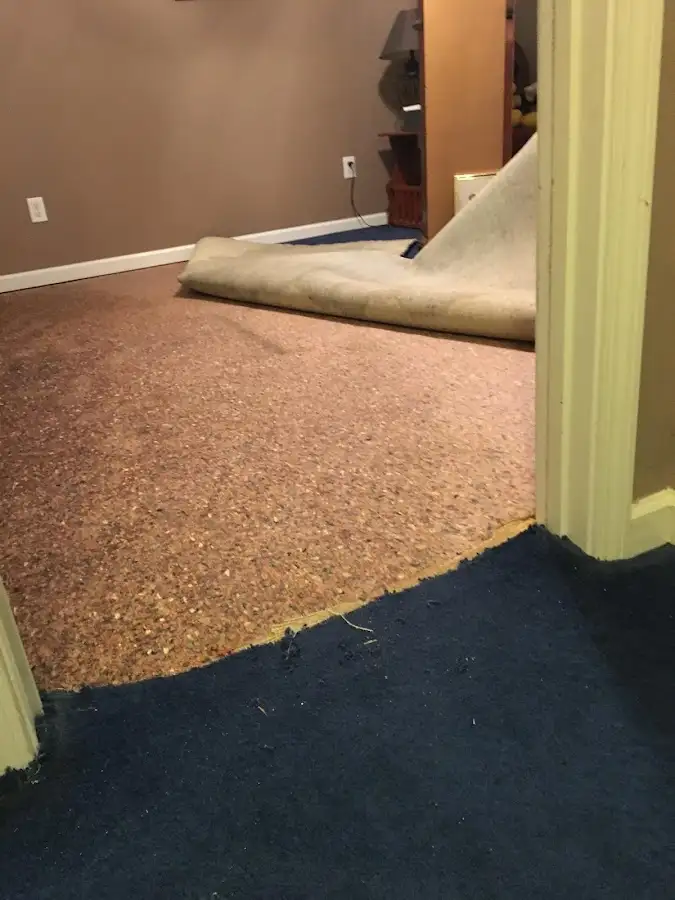 Carpet pad removal revealing water damage during Water Mitigation Services in Fuller Heights